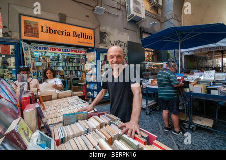 Port'Alba, die Straße der Bücher. Der Buchhändler Gianfranco Pacifico posiert vor seinem Geschäft unter den gebrauchten Bücherständen. Neapel, Italien. Stockfoto