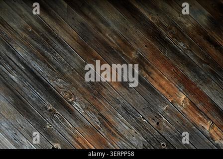 Nahaufnahme einer stark verwitterten Holzplatte auf einer Diagonale mit abgenutzter brauner Beize, freiliegender natürlicher Holzpatina Stockfoto