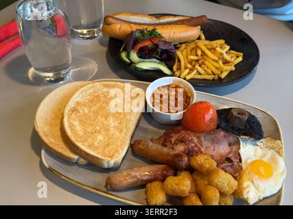 Komplettes englisches Frühstück und Hot Dog mit Pommes frites – herzhaftes Café-Brunch-Essen im kommerziellen Hintergrund Stockfoto