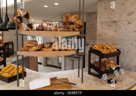 Eine wunderschöne Präsentation von frisch gebackenem Brot, Brötchen und traditionellen sternförmigen Broten auf modernen Holzregalen. Dieses Restaurant Frühstücksbüfett Stockfoto