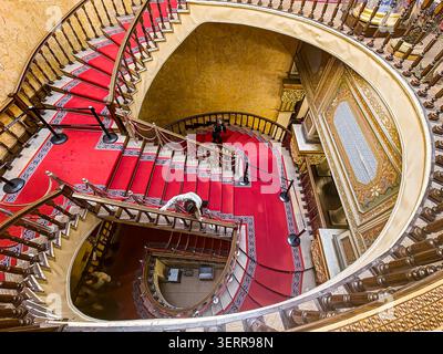 Blick auf die große, reich verzierte Wendeltreppe mit rotem Teppich im Beylerbeyi-Palast in Istanbul, Türkei - 27. Februar 2026. Stockfoto