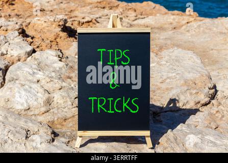 Symbol für Tipps und Tricks. Konzeptworte Tipps und Tricks auf der schönen schwarzen Tafel. Wunderschöner Steinhintergrund. Geschäftliche Tipps und Tricks motiva Stockfoto