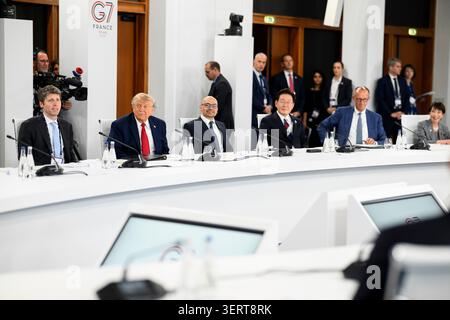 Evian-les-Bains, Frankreich. 17. Juni 2026. US-Präsident Donald Trump, 2. Links, hört während der Arbeitssitzung des G7-Gipfels zu KI und digitalen Themen im Hotel Royal Evian am 17. Juni 2026 in Evian-les-Bains, Frankreich. Von links sitzend: Der CEO von Open AI Sam Altman, Trump, der CEO von Google DeepMind, Demis Hassabis, der südkoreanische Präsident Lee Jae Myung, der deutsche Bundeskanzler Friedrich Merz und der japanische Premierminister Sanae Takaichi. Quelle: Daniel Torok/White House Photo/Alamy Live News Stockfoto