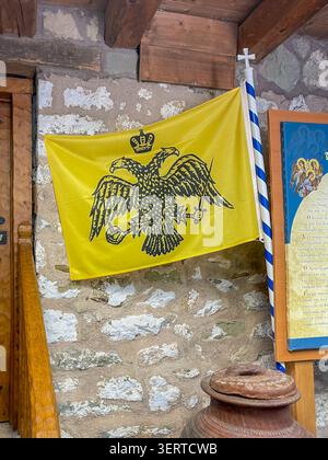 Kalambaka, Griechenland - 23. Juli 2024: Die gelbe Flagge mit einem Doppeladler und einer Krone darüber steht in Verbindung mit der orthodoxen Kirche, insbesondere u Stockfoto