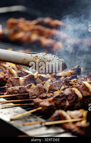 Gegrillte Fleischspieße Kochen auf Barbecue Grill mit aufsteigendem Rauch Stockfoto