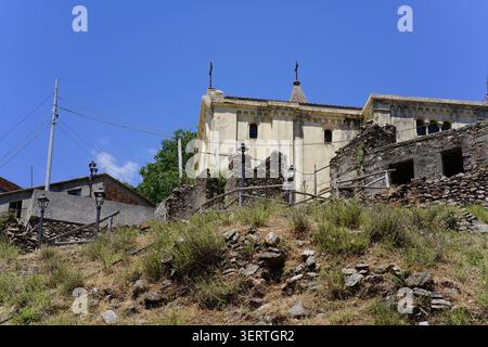 Kirche mit Kreuzen auf dem Dach zwischen Steinruinen im verlassenen Dorf Ghorio di Roghudi im Nationalpark Aspromonte, Kalabrien, Süditalien. Stockfoto