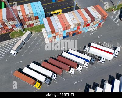 Luftaufnahme eines Logistikzentrums mit mehrfarbigen Versandcontainern und Lkws Stockfoto