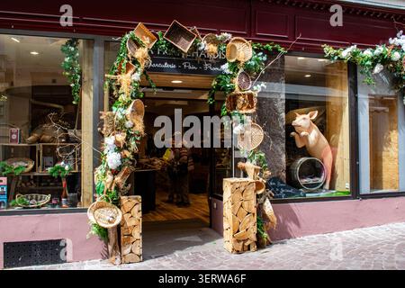 Traditionelle Wurst- und Delikatessen im historischen Zentrum von Colmar, Elsass, Frankreich, rustikale Körbe, Blumendekorationen, Schweinefigur – Schaufenster. Stockfoto