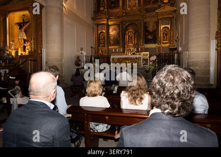 Leute sitzen in Bänken und hören einem Priester zu, der von der Kanzel spricht Stockfoto