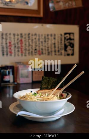 Traditionelle japanische Ramen-Schüssel mit Chashu Schweinefleisch Nori und Essstäbchen im Restaurant Stockfoto