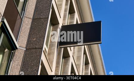 Für Werbemodellvorlagen, die leere Ladenschilder an der Außenfassade eines Gebäudes zeigen, ist Eine leere Werbetafel auf dem angebracht, die eine individuelle Branding-Möglichkeit für Einzelhandelswerbung und Urban bietet. Stockfoto