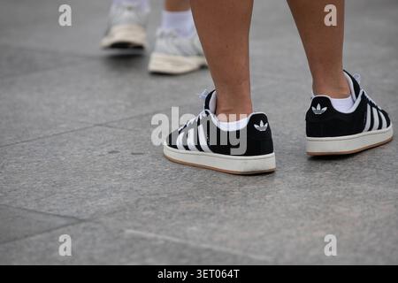 BANGKOK, THAILAND - 30. MAI 2026: Mann, der in schwarzen Adidas-Sneakers läuft, Hochwinkelansicht. Stockfoto