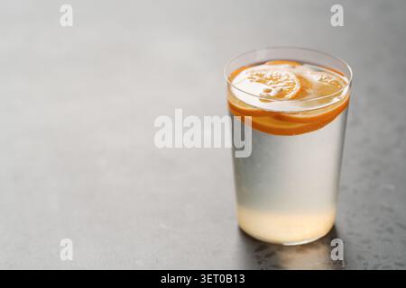 Organische Limonade in Tumbler-Glas auf Betonhintergrund mit Kopierraum Stockfoto