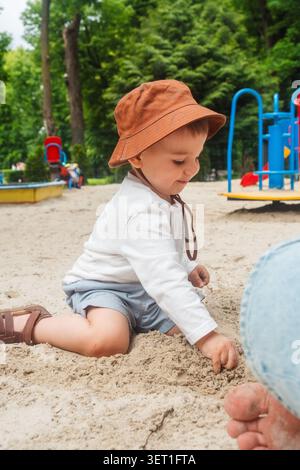 Kleinkind in Sun hat im Sandy Playground Park Stockfoto