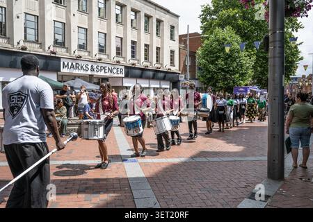 Eine Marschaufführung des SEC Drum Corps, die entlang der Fußgängerzone Broad Street vor Marks & Spencer im Stadtzentrum von Reading, Berkshire, marschiert. Stockfoto