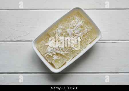 thailändischer süßer Maniokkuchen oder Maniokpudding mit Kokosspänen in Plastikbehältern vom Street Food Market Stockfoto