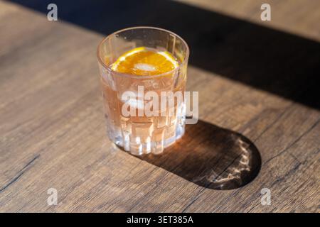 Nahaufnahme eines erfrischenden Pink Gin Fizz Cocktails garniert mit frischen Beeren und Rosmarin Stockfoto