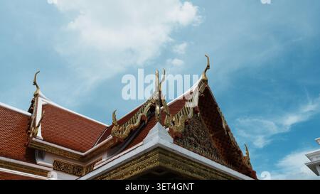 Traditioneller Thailändischer Tempel Rotes Dach Mit Terrakotta-Fliesen Vor Klarem Hellen Blauen Himmel Stockfoto