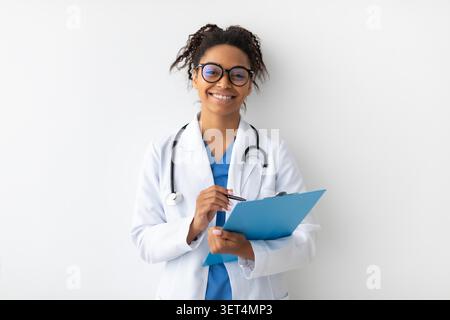 Glückliche Afroamerikanische Ärztin Lächelt Mit Clipboard In Klinik, Gesundheitskonzept Stockfoto