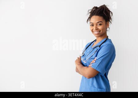 Lächelnde Schwarze Krankenschwester Steht Selbstbewusst Mit Gekreuzten Armen Im Gesundheitswesen Stockfoto
