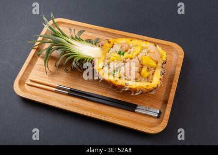 Thai Pineapple Fried Rice serviert in Ananasschale mit Garnelen Stockfoto