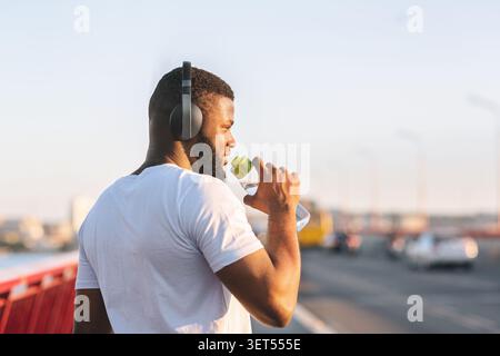 Rückansicht des afrikanischen amerikanischen Jungen Mann Trinkwasser Stockfoto