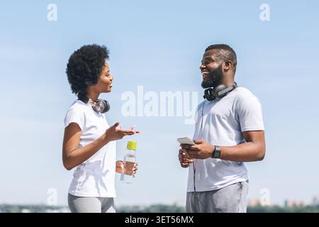 Paar sprechen über Laufen Training Plan in der Nähe des Flusses Stockfoto