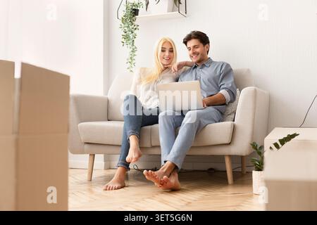 Entspannt junger Mann und Frau mit Laptop auf der Couch Stockfoto