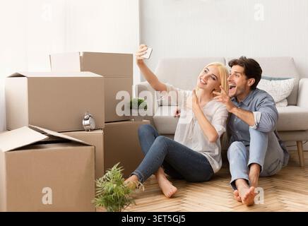 Ein Paar genießt einen lustigen Moment, während er in seinem neuen Zuhause die Kartons auspackt Stockfoto