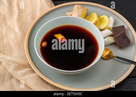 Traditioneller chinesischer Ingwertee mit braunem Zucker und Zwiebelstielen in einer Keramikschale, Kräutermittel zur Erkältungsvorsorge Stockfoto