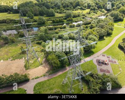 Drohnen-Luftbild mit Strommasten, die den Gunpowder Park in der Nähe von Waltham Abbey in Essex überqueren, mit grüner Landschaft und Wanderwegen darunter. Stockfoto