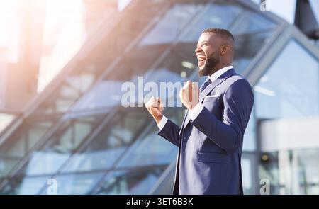 Fröhlicher Geschäftsmann Schreit, Der In Der Stadt Die Fäuste Schüttelt Stockfoto