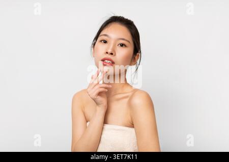 Junge Asiatische Frau Posiert Mit Hand Auf Chin, Natural Beauty And Skincare Concept Stockfoto