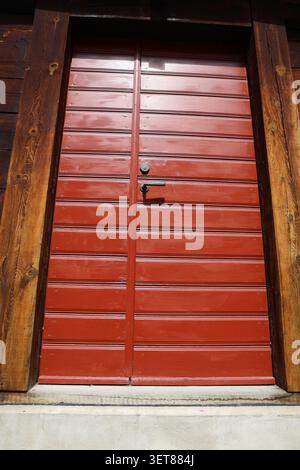 Alte rote Holztür in Visby, Gotland, Schweden, in einem historischen mittelalterlichen Steingebäude. Stockfoto