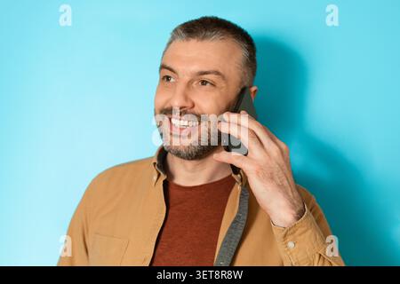 Lächelnder Kaukasier Mittleren Alters, Der Auf Dem Smartphone Spricht, Copy Space Stockfoto