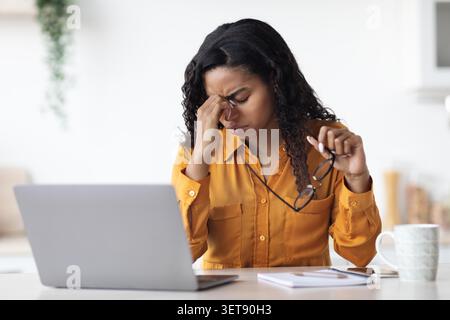 Besorgte Junge Schwarze Frau, Die Im Home Office An Laptop Arbeitet Und Stress Erlebt Stockfoto