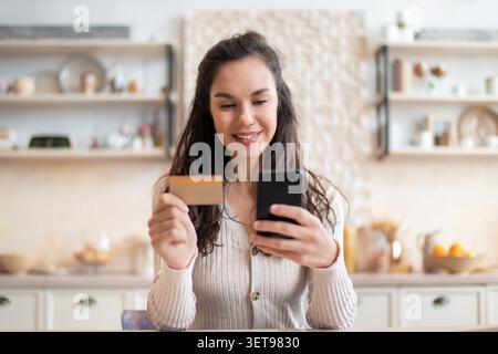 Glückliche Junge Frau Mit Kreditkarte Und Smartphone Online-Shopping Zu Hause, Business-Konzept Stockfoto