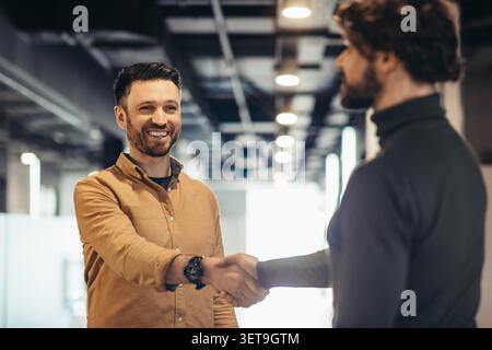Ein Lächelnder Kaukasier Schüttelt Hand Mit Einem Kollegen In Modern Office, Business Concept Stockfoto