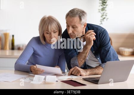 Älteres Kaukasisches Ehepaar, Das Finanzen Zu Hause Gemeinsam Verwaltet, Konzentriert Sich Auf Papierkram, Geschäftskonzept Stockfoto
