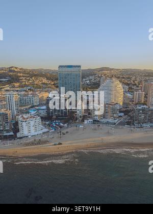 Blick aus der Vogelperspektive auf moderne Hochhäuser entlang der Sandküste und des ruhigen Meeres in Calp, Valencianische Gemeinschaft, Spanien. Stockfoto