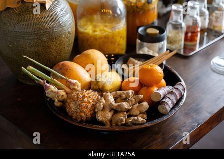 Tropische Frucht Ingwer Kurkuma Zuckerrohr Zitrus Papaya Ananas Zitronengras Holztisch rustikaler Stil frisch Bio gesund natürliche lebendige Küche in Stockfoto