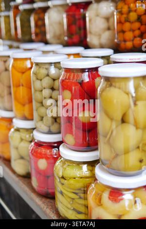 Gläser mit bunten Obst- und Gemüsekonserven auf einem Markt Stockfoto