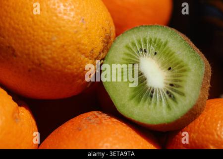 Die Früchte sind in einem Korb mit einer geschnittenen Kiwi angeordnet Stockfoto