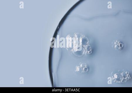Nahaufnahme von Blasen in transparentem Gel auf hellblauem Hintergrund Stockfoto