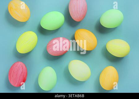 Bunte Eier in Pastellfarben auf grünem Hintergrund. Osterdekor mit Blick von oben Stockfoto