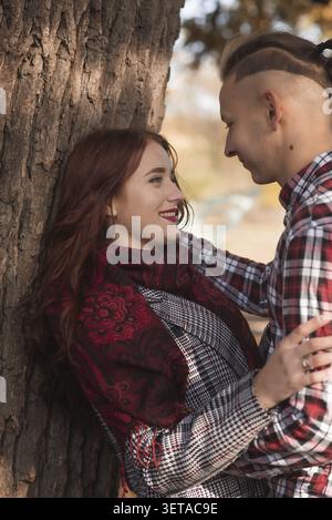 Junges Paar, das im Herbst Park spazieren geht und Spaß hat. Sie umarmen sich, vor dem Hintergrund von Herbstbäumen. Das Konzept der Romantik, der Fall i Stockfoto
