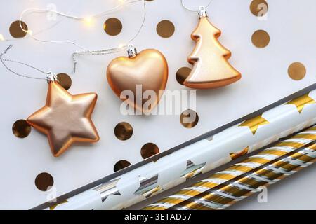 Weihnachtsgoldschmuck, Stern, Weihnachtsbaum, Herz, Geschenkpapier, goldenes Konfetti auf weißem Hintergrund Weihnachtskomposition flach gelegt, Ansicht von ab Stockfoto