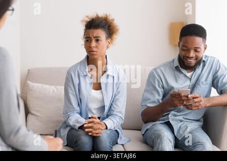 Afro Mann spielen Telefon Besuch Paare Therapie mit Frau Stockfoto