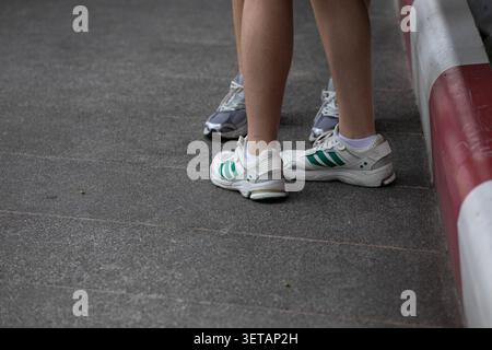 BANGKOK, THAILAND - 30. MAI 2026: Frauen in Turnschuhen stehen zusammen, Hochwinkelansicht. Stockfoto