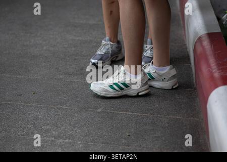 BANGKOK, THAILAND - 30. MAI 2026: Frauen in Turnschuhen stehen, Hochwinkelansicht. Stockfoto
